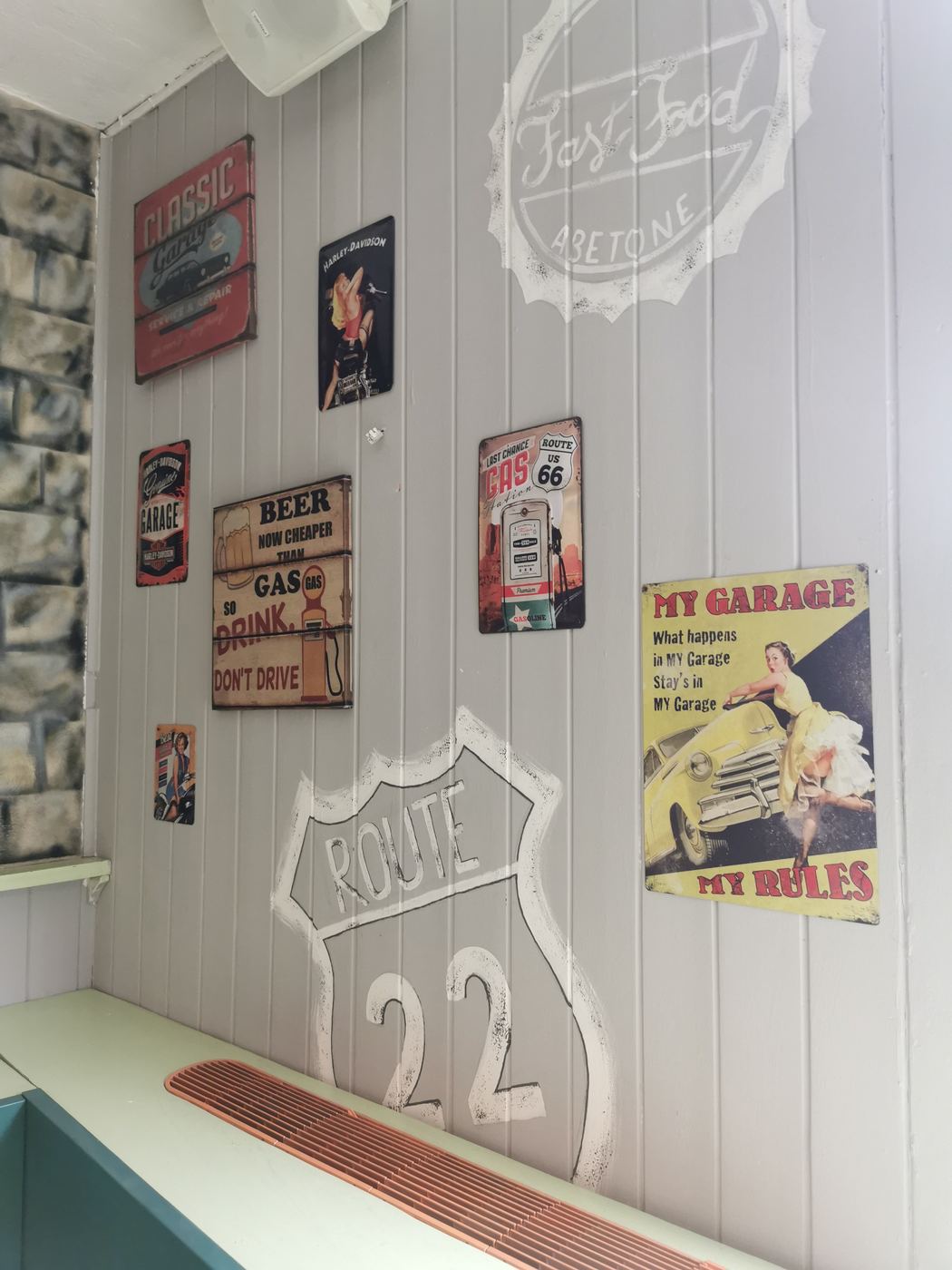 Insegne vintage in latta e la scritta Route 22 sulla parete