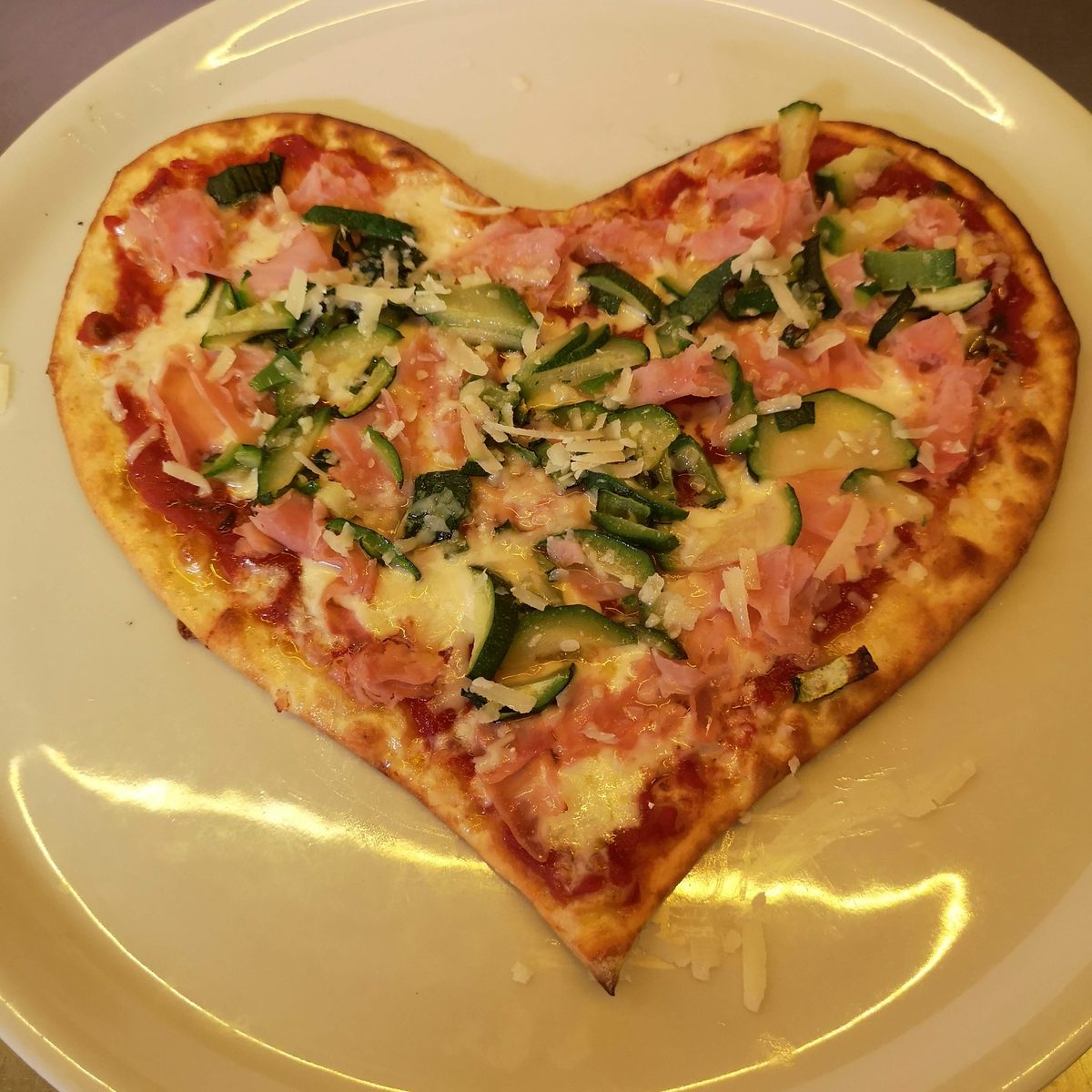 Pizza a forma di cuore con prosciutto e zucchine