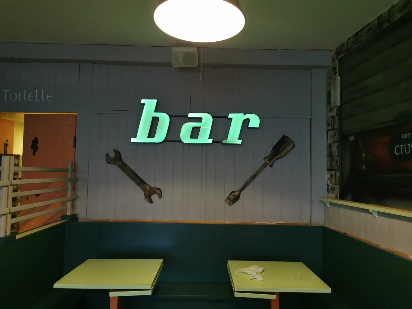La sala con l'insegna luminosa bar, chiave inglese e cacciavite
